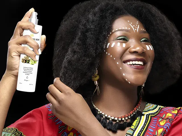 Femme souriante qui vaporise une brume sur son visage